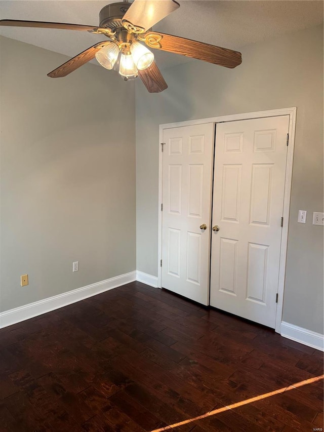 unfurnished bedroom featuring dark hardwood / wood-style flooring, a textured ceiling, a closet, and ceiling fan