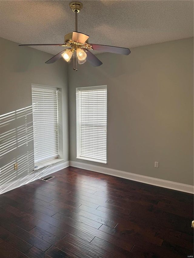 empty room with ceiling fan, a textured ceiling, and dark hardwood / wood-style flooring