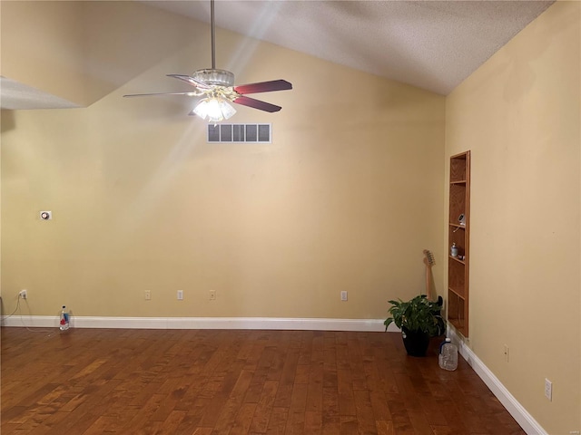 empty room featuring a textured ceiling, ceiling fan, dark wood-type flooring, high vaulted ceiling, and built in shelves