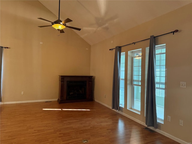 unfurnished living room featuring vaulted ceiling, hardwood / wood-style flooring, and ceiling fan