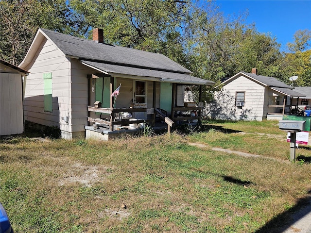 bungalow-style home featuring covered porch and a front lawn