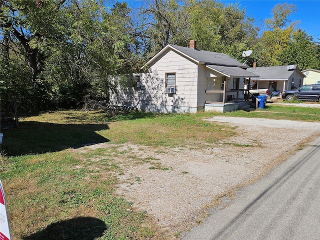 view of home's exterior with a lawn and covered porch