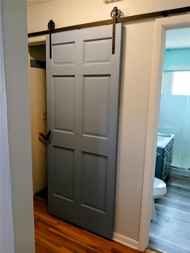 room details featuring hardwood / wood-style floors and a barn door