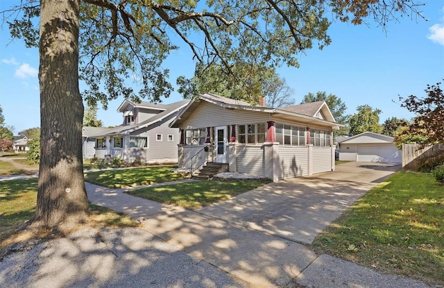 view of front facade featuring a garage, a front lawn, and an outdoor structure