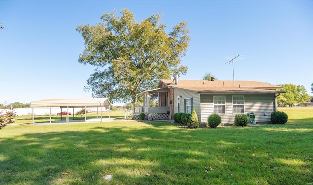 rear view of house featuring a yard and a carport