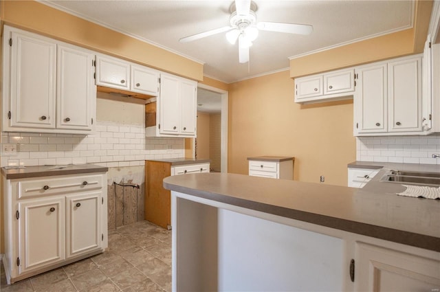 kitchen with ornamental molding, white cabinets, and ceiling fan