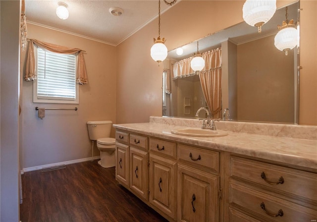 bathroom featuring a textured ceiling, wood-type flooring, toilet, vanity, and crown molding