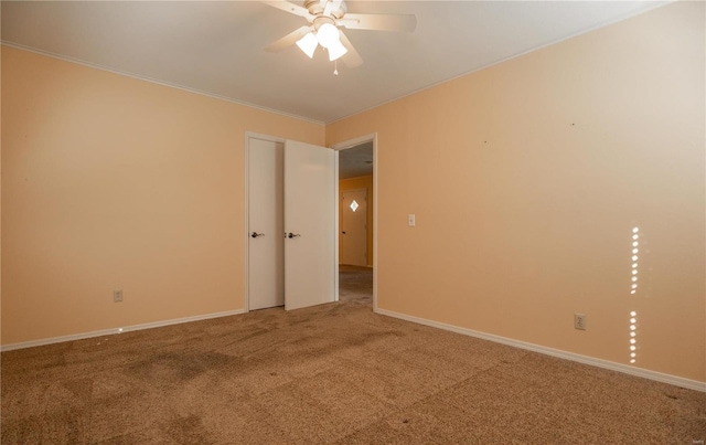 carpeted spare room featuring crown molding and ceiling fan