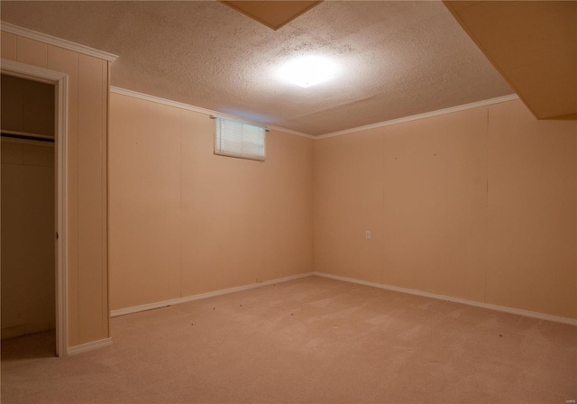 basement featuring crown molding, carpet flooring, and a textured ceiling