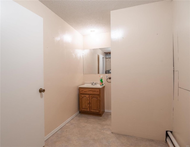 bathroom with vanity, a textured ceiling, and a baseboard radiator