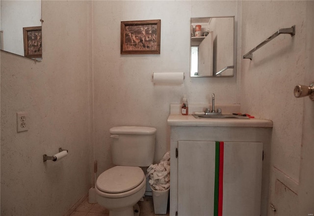 bathroom with vanity, toilet, and tile patterned floors