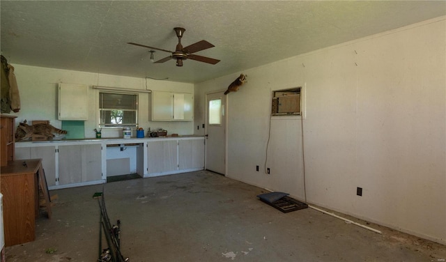 kitchen with a textured ceiling, a wall mounted air conditioner, and ceiling fan