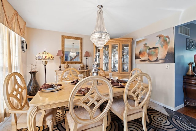 tiled dining space featuring an inviting chandelier