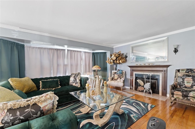 living room featuring crown molding, hardwood / wood-style flooring, and a tiled fireplace