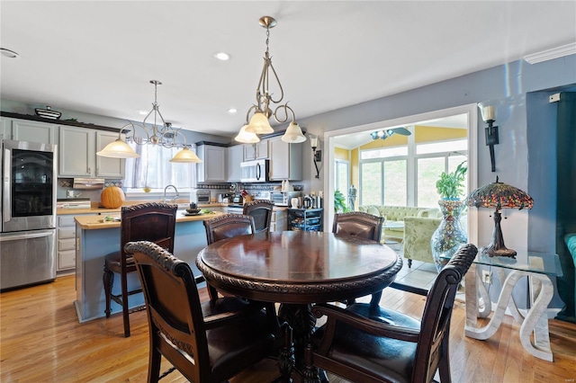 dining area featuring light hardwood / wood-style flooring, a chandelier, and plenty of natural light