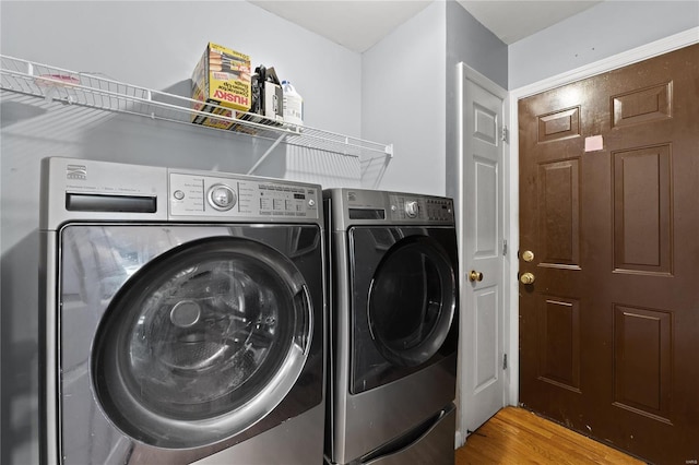 laundry area featuring washing machine and dryer and wood-type flooring