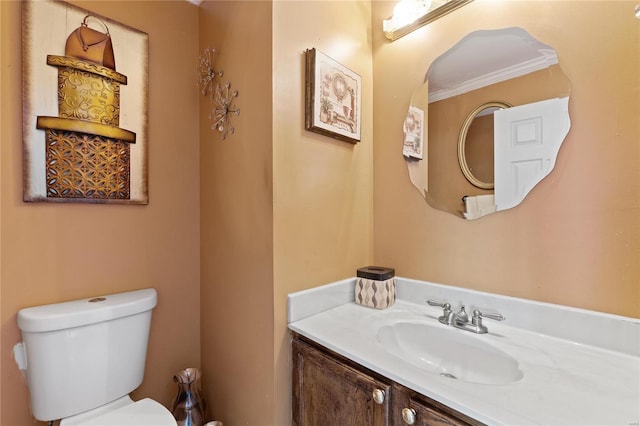 bathroom featuring toilet, crown molding, and vanity