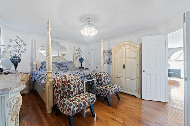 bedroom featuring wood-type flooring, ornamental molding, and a chandelier