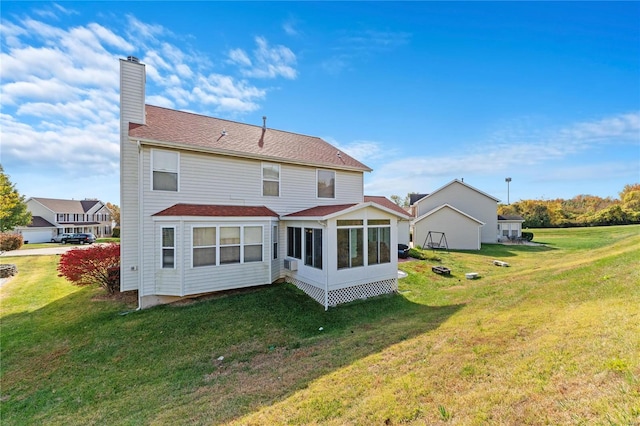 rear view of property featuring a lawn and a sunroom