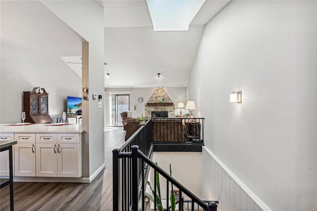 hallway featuring dark hardwood / wood-style flooring and vaulted ceiling