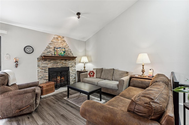 living room with hardwood / wood-style flooring, a fireplace, and vaulted ceiling