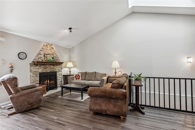 living room featuring a fireplace, wood-type flooring, and vaulted ceiling