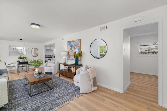 living room featuring an inviting chandelier and light wood-type flooring