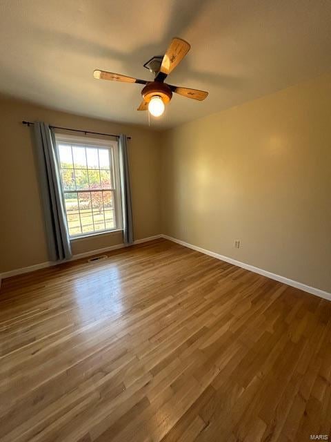 empty room featuring ceiling fan and hardwood / wood-style floors