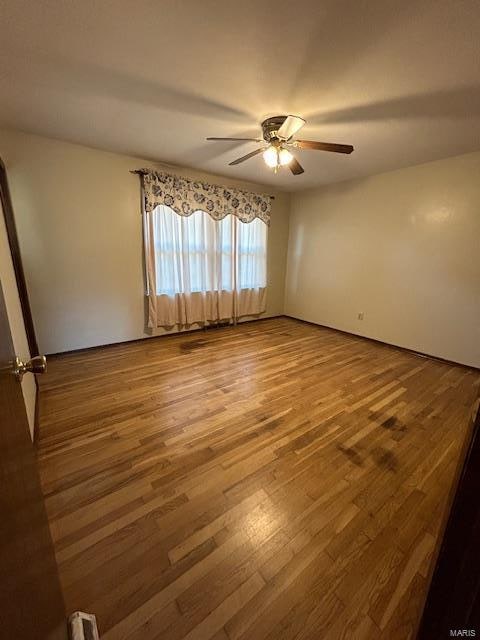 spare room featuring hardwood / wood-style flooring and ceiling fan