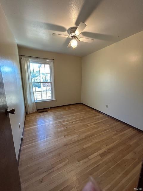 spare room with light hardwood / wood-style flooring and ceiling fan