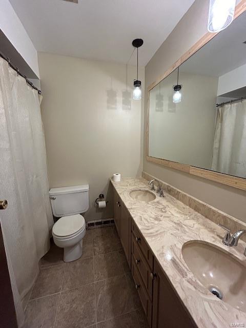 bathroom with vanity, toilet, and tile patterned floors