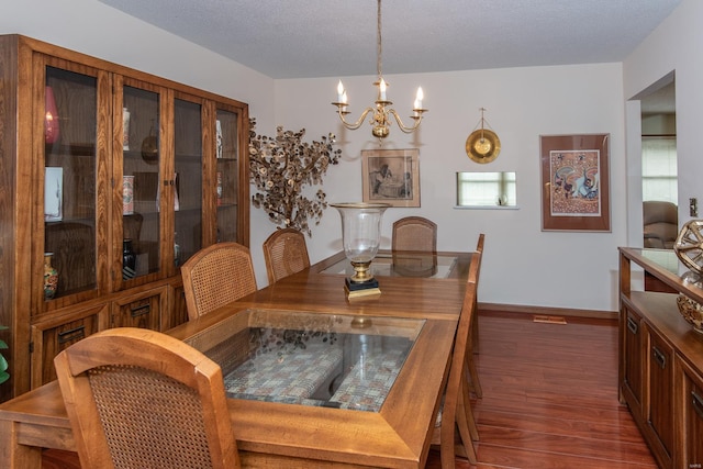 dining area with dark hardwood / wood-style floors, a chandelier, and a textured ceiling