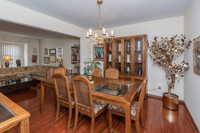 dining space with hardwood / wood-style flooring, a textured ceiling, and a chandelier