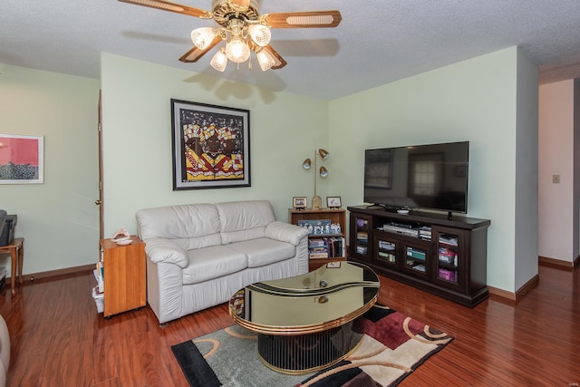 living room with ceiling fan, a textured ceiling, and dark hardwood / wood-style flooring