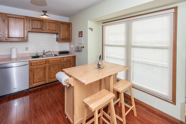 kitchen featuring sink, backsplash, a textured ceiling, dark hardwood / wood-style flooring, and stainless steel dishwasher