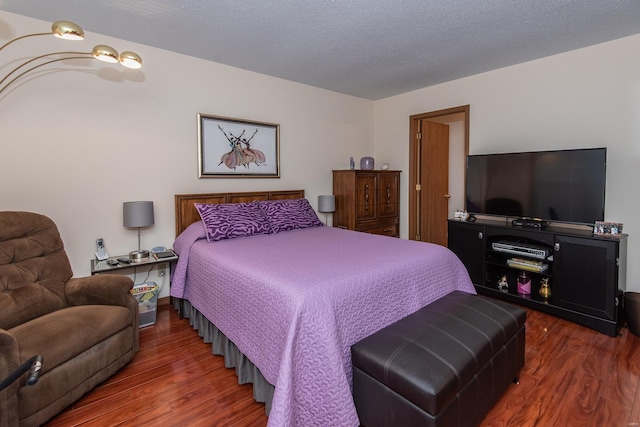 bedroom featuring a textured ceiling and dark hardwood / wood-style flooring