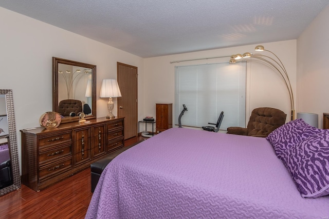 bedroom with a textured ceiling and dark hardwood / wood-style floors