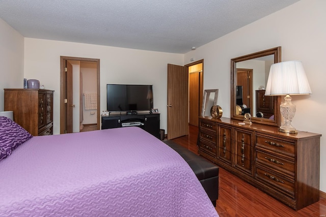 bedroom with dark hardwood / wood-style floors and a textured ceiling