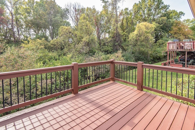 wooden terrace featuring a lawn