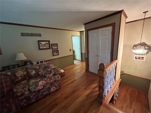 living room featuring ornamental molding, hardwood / wood-style floors, and a notable chandelier