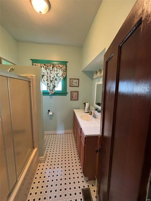 bathroom with vanity and a shower with shower door