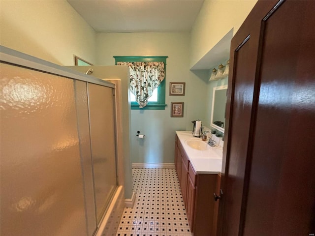 bathroom with a shower with shower door and vanity