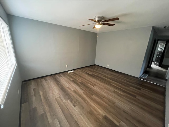 empty room featuring ceiling fan and dark hardwood / wood-style flooring