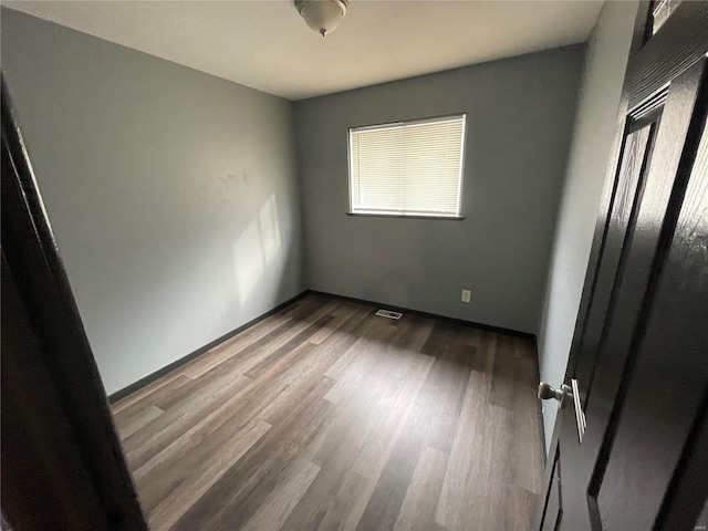 unfurnished room with wood-type flooring