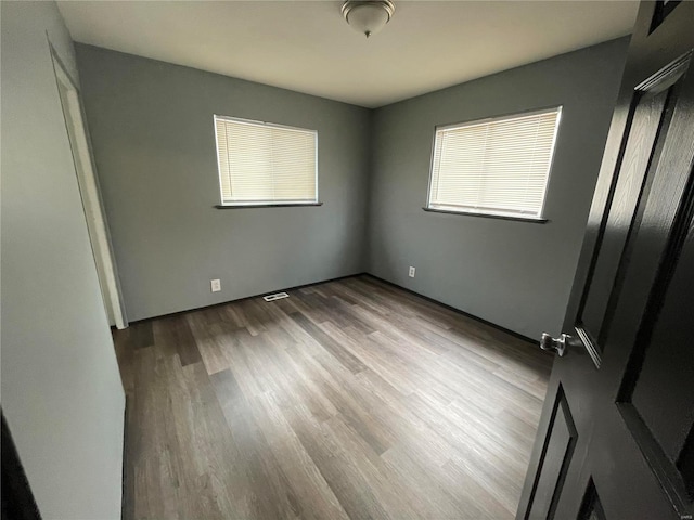 unfurnished bedroom with multiple windows and light hardwood / wood-style floors