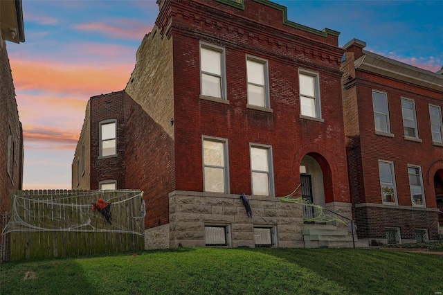 property exterior at dusk with a yard