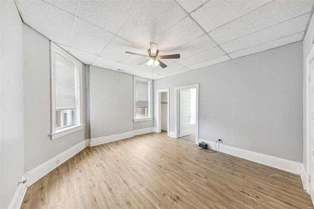 unfurnished room with a drop ceiling, light hardwood / wood-style flooring, and ceiling fan