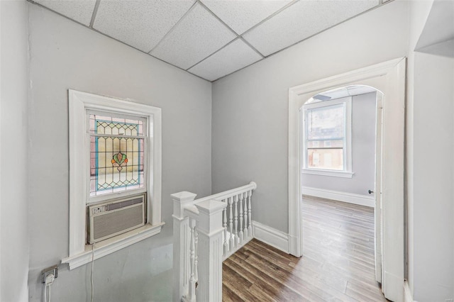 hallway featuring a drop ceiling, cooling unit, and hardwood / wood-style flooring