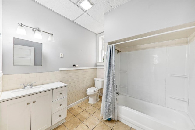 full bathroom featuring toilet, tile patterned flooring, tile walls, vanity, and shower / bathtub combination with curtain