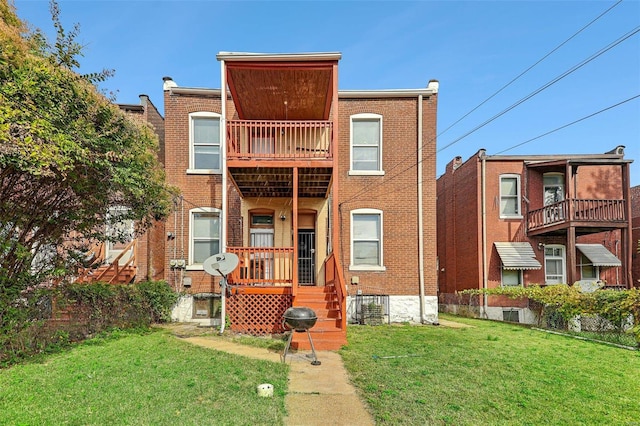 rear view of property featuring a lawn and a balcony